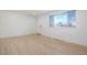 Spacious living area with light hardwood floors and large window at 7956 Joan Dr, Denver, CO 80221