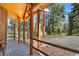 Wooden porch with log railings, offering wooded views at 26196 Rea Ave, Conifer, CO 80433