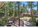 Deck overlooks a wooded area with a view of a distant home at 26196 Rea Ave, Conifer, CO 80433