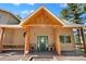 Inviting front entrance with a wood-beamed covered porch at 26196 Rea Ave, Conifer, CO 80433