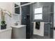 Modern bathroom with dark gray tile, glass shower, and white vanity at 1925 S Hazel Ct, Denver, CO 80219