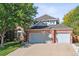 Brick two-story home with a three-car garage at 5627 S Idalia St, Centennial, CO 80015