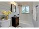 Clean bathroom with a dark vanity and geometric tile floor at 1245 Tamarac St, Denver, CO 80220