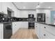 Modern kitchen with white cabinets, granite countertops, and stainless steel appliances at 5552 Flanders Way, Denver, CO 80249