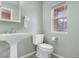 Clean bathroom with pedestal sink, toilet, and a window at 5552 Flanders Way, Denver, CO 80249
