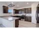 Modern kitchen with dark cabinets, granite counters, and stainless steel appliances at 341 Maple St, Bennett, CO 80102