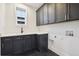 Modern laundry room with dark cabinetry and patterned tile floor at 2504 Zenobia St, Denver, CO 80212