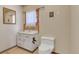 Bathroom with white vanity, toilet, and decorative mirror at 30232 Hilltop Dr, Evergreen, CO 80439