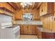 Kitchen with wood cabinetry, a gas stove, double sink, and wood paneling at 30232 Hilltop Dr, Evergreen, CO 80439