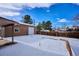 Backyard view of detached garage and snow-covered yard at 8503 S Balsam St, Littleton, CO 80128