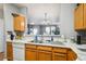 The kitchen's double sink and pass-through window offer both functionality and a view to the dining area at 126 Foxglove Dr, Brighton, CO 80601