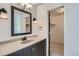 Bathroom with dark vanity, speckled countertop, and linen closet at 2466 S Vaughn Way # B, Aurora, CO 80014