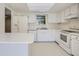 Galley kitchen with white cabinets and speckled countertops at 2466 S Vaughn Way # B, Aurora, CO 80014