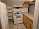 Small basement kitchen with wood cabinets and a gas range at 3114 W Gill Pl, Denver, CO 80219