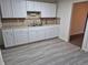 White kitchen with laminate flooring and updated cabinets at 3114 W Gill Pl, Denver, CO 80219