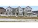 Exterior view of four townhomes with white railings, green siding, and solar panels at 14554 W 91St Dr # A, Arvada, CO 80005