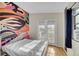 Bright bedroom with a double bed, access to a balcony, and an artistic wall mural at 1550 S Telluride St, Aurora, CO 80017