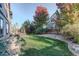 Landscaped backyard with grassy area, gravel pathway, and a view of a deck at 5033 Silver Feather Way, Broomfield, CO 80023