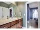 Clean bathroom with a vanity, sink, and view into a bedroom at 5033 Silver Feather Way, Broomfield, CO 80023