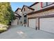 Two-story house with stone exterior, three car garage, and landscaping at 5033 Silver Feather Way, Broomfield, CO 80023