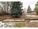 Landscaped backyard with a large tree and retaining wall at 436 Devinney Ct, Golden, CO 80401