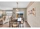 Bright dining room features a wood table, sliding glass door to backyard, and modern light fixture at 11865 Barrentine Loop, Parker, CO 80138