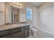 Clean bathroom with a shower/tub combo, vanity with dark brown cabinets, and a window at 15325 W 93Rd Ave, Arvada, CO 80007