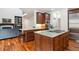 Open kitchen with granite island, custom cabinetry, and hardwood floors at 8715 E Iliff Dr, Denver, CO 80231