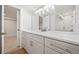 Modern basement bathroom with white cabinetry, quartz countertops, and a large mirror at 6690 S Sheridan Blvd, Littleton, CO 80123