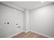 Bright laundry room in basement with washer and dryer hookups and wood-look flooring at 6690 S Sheridan Blvd, Littleton, CO 80123