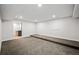 Finished basement recreation room with neutral carpet and built-in shelving at 6690 S Sheridan Blvd, Littleton, CO 80123
