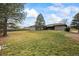 Large backyard with mature trees and a view of the back of the house at 6690 S Sheridan Blvd, Littleton, CO 80123