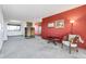 Spacious living room with carpeted floors, red accent wall, and views to the outside at 11505 Roxburg St, Strasburg, CO 80136