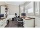 Bright home office features built-in shelving, large desk, and hardwood floors at 7587 Wright Ct, Arvada, CO 80005