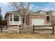 Brick ranch home with a two-car garage and a partially fenced front yard at 16523 Prairie Flower Pl, Parker, CO 80134