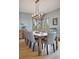 Elegant dining room with a large wooden table, gray chairs, and a modern chandelier at 12421 High Country Trl, Littleton, CO 80127