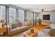 Virtually staged living room with hardwood floors, large windows, and a neutral color palette at 1626 S Sheridan Blvd, Denver, CO 80232