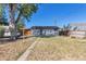 Backyard view of the house with a large tree and patio at 1626 S Sheridan Blvd, Denver, CO 80232