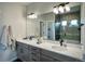 Modern bathroom with double vanity, large mirror, and walk-in shower at 16707 Greyhawk Dr, Monument, CO 80132