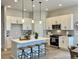 Modern kitchen with white cabinets, large island with seating, and stainless steel appliances at 16707 Greyhawk Dr, Monument, CO 80132