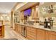 Basement wet bar with granite countertop and wine cooler at 5230 Bow Mar Dr, Littleton, CO 80123