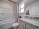 Clean bathroom with shower/tub combo, granite vanity, and linen shelves at , Commerce City, CO 80022