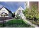 Charming gray house with black fence, small tree, and manicured lawn at 1473 Yates St, Denver, CO 80204