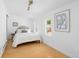 Bright bedroom with light wood floors, a queen bed, and a large window at 1473 Yates St, Denver, CO 80204