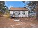 White home with brown roof, steps, and small deck at 656 N Russellville Rd, Franktown, CO 80116