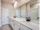 Modern bathroom with double sinks, white vanity, large mirror, and tiled shower at 27462 E 1St Ave, Aurora, CO 80018