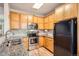 Galley kitchen with granite counters, stainless steel appliances, and light wood cabinets at 1140 Opal St # 103, Broomfield, CO 80020