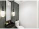 Small bathroom with dark green tile, a floating vanity, and modern lighting at 4121 Kalamath St, Denver, CO 80211