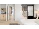Bright bedroom with light flooring, access to a bathroom and hallway leading to upper level at 4121 Kalamath St, Denver, CO 80211