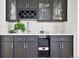 Modern wet bar with dark cabinetry, wine rack, and ice maker at 29775 E 162Nd Ave, Brighton, CO 80603